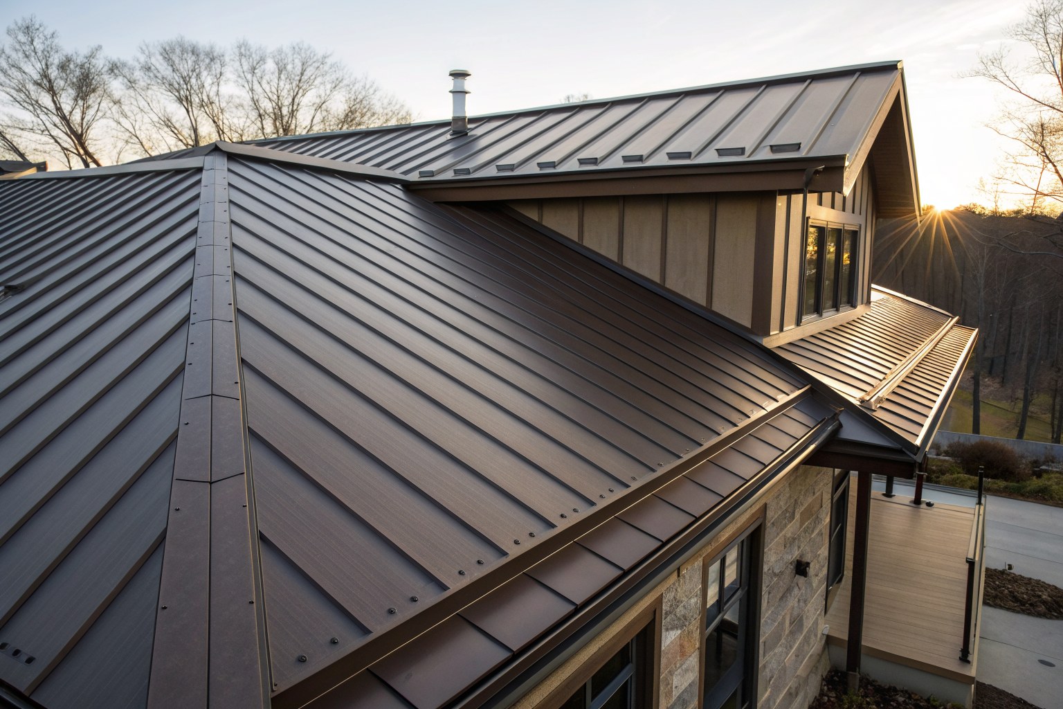 Close view of dark bronze standing-seam metal panels meeting at a ridge